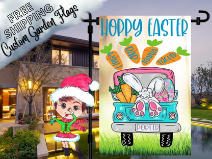 Happy Easter garden flag with a turquoise truck, bunny feet, colorful eggs and named carrots on cream shown at dusk.