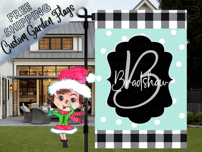 Mint polka-dot Bradshaw family garden flag with a script B monogram, black label and check borders in front of a porch.