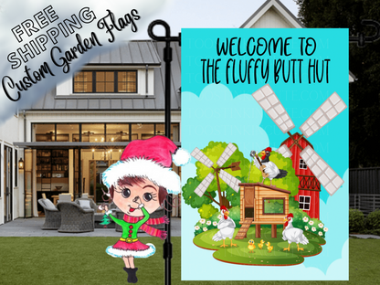 Fluffy Butt Hut welcome flag with chickens, coop and red windmill, displayed beside a white house.