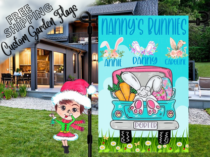 Nanny's Bunnies garden flag with floral bunny-ear motifs, names and a turquoise Easter truck outside a house.