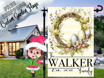 Walker family garden flag with pastel Easter eggs, a twig-and-foliage wreath and pale yellow stripes beside a white house.