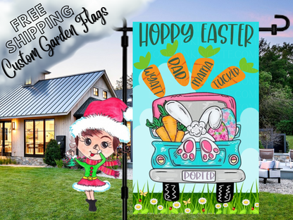 Happy Easter flag with a turquoise truck, bunny feet, colorful eggs and named carrots, shown beside a white house.