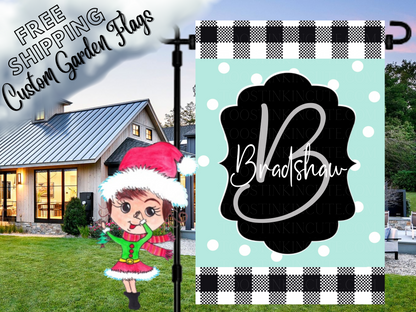 Mint polka-dot Bradshaw family garden flag with a script B monogram, black label and check borders beside a white house.