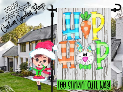 Hip Hop Easter garden flag with a carrot, bunny face and colorful letters, shown in a daytime yard.