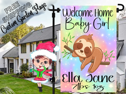 Welcome Home Baby Girl garden flag with a sloth, rainbow background, Ella Jane example name and birth details in a daytime yard.