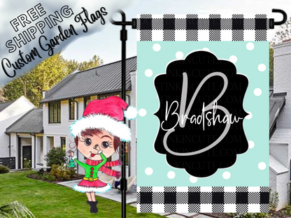 Mint polka-dot Bradshaw family garden flag with a script B monogram, black label and check borders in a daytime yard.