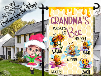 Grandma’s Reasons to Bee Happy garden flag with five named cartoon bees, colorful flowers, a purple heading and honeycomb design. Shown in a daytime yard.