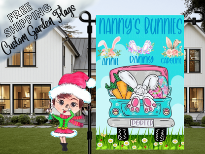 Nanny's Bunnies garden flag with floral bunny-ear motifs, names and a turquoise Easter truck in a close garden-stand view.
