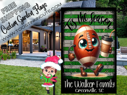 Football garden flag mockup with a smiling football holding a drink and 'Tis the Season lettering, displayed by a house.