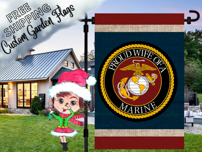 Proud Wife of a Marine garden flag with a Marine Corps eagle, globe and anchor emblem, navy background and red and cream bands. Shown at dusk.