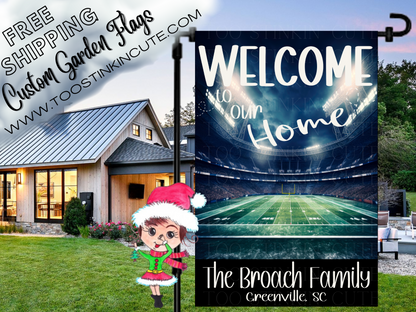 Welcome to Our Home garden flag with a lighted football stadium, green field, Broach family name and Greenville, SC text. Shown in a yard at dusk.