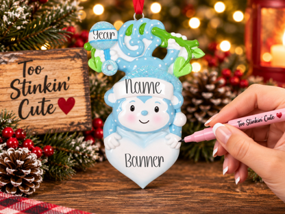 Custom name baby boy ornament with a glittery blue Santa hat and playful details