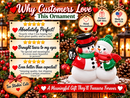 Snowman couple ornament with a small black lantern hanging beside the left snowman.