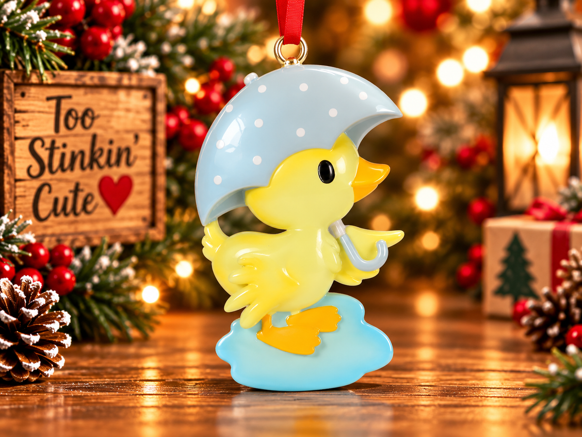 Personalized yellow duck ornament displayed in a warm Christmas setting with lights, greenery and red berries