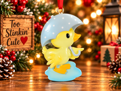 Personalized yellow duck ornament displayed in a warm Christmas setting with lights, greenery and red berries