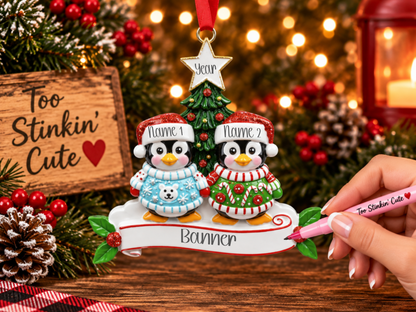 Custom couple ornament with two penguins wearing colorful Christmas sweaters.