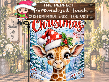 Winter animal yard flag featuring an adorable giraffe with large eyes against a snowy blue woodland Christmas scene.