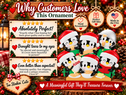 Six penguin baking Christmas ornament hanging from a red ribbon against warm holiday lights.