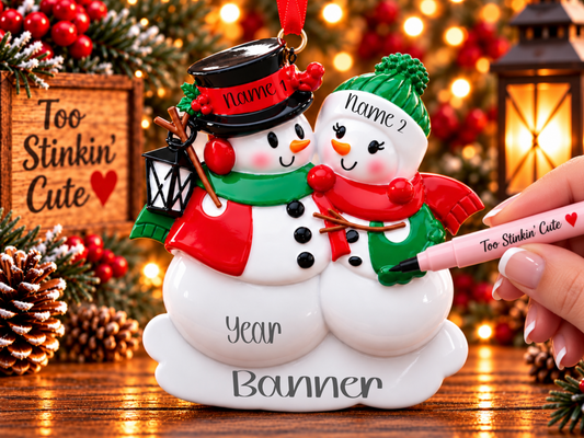 Left snowman wearing a black top hat with a red band and holly, a green scarf, and red winter clothing.