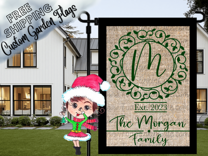 Burlap-look garden flag mockup with a green M monogram, ornate circular frame, establishment year and Morgan family name.