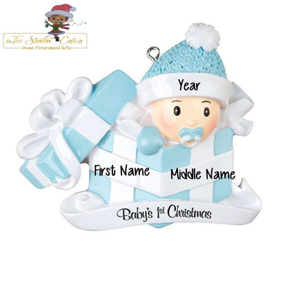 Christmas Ornament showing baby boy emerging from a blue-and-white present and blue bow and rattle.