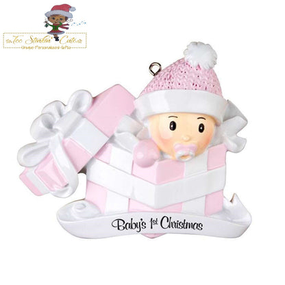 Christmas Ornament showing baby girl emerging from a pink-and-white gift and pink bow and rattle.